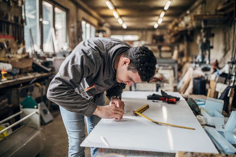 Artisan qui coupe du plexiglas